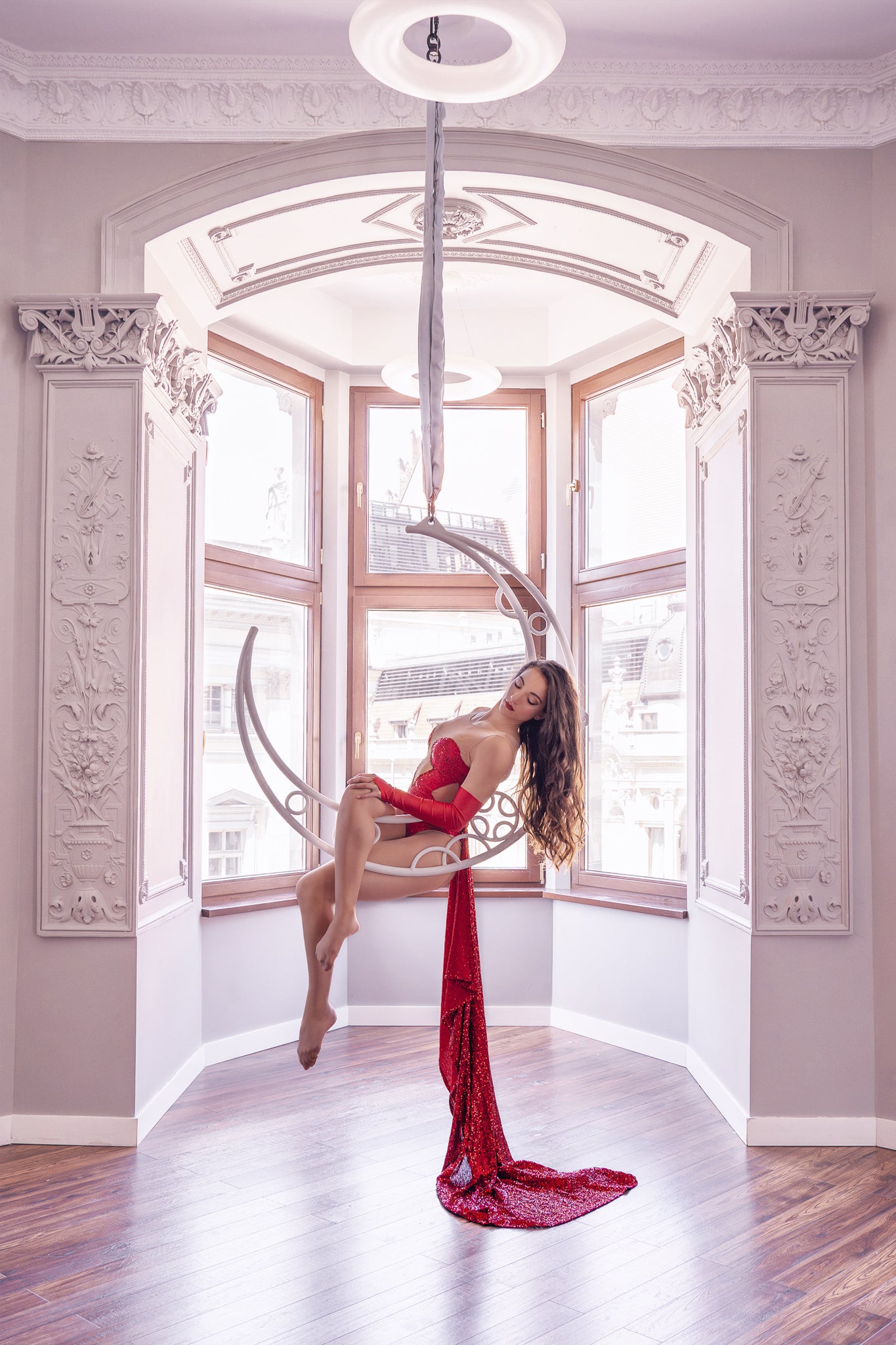 Modella con body rosso e gonna sul cerchio aereo